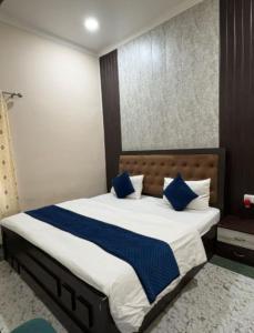 a bedroom with a large bed with blue pillows at Hotel Indra Palace Jaunpur in Jaunpur