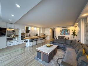 a living room with a couch and a kitchen at Amelia Terrace Escape in Tbilisi City