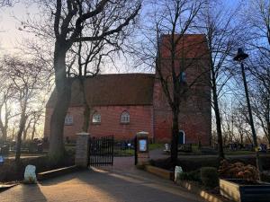 a red brick building with a tree in front of it at Ferienhaus Teenös in Hinte