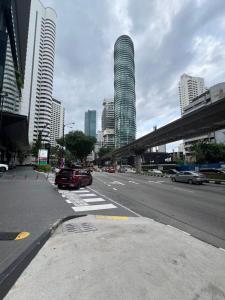 a city street with cars driving down a street with tall buildings at Apartment klcc area in Kuala Lumpur
