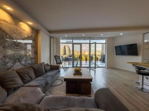 a living room with a couch and a table at Amelia Terrace Escape in Tbilisi City
