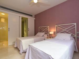 2 bedden in een kamer met paarse muren bij Las Barcas in San Agustin