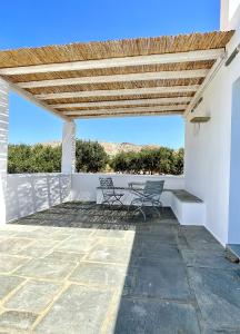 a patio with two chairs and a table at Iosub Houses & Studios - Beach House in Koumbara in Tzamaria