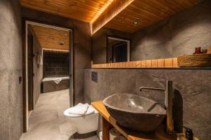 a bathroom with a stone sink and a toilet at Gáldu Hotel & Spa in Saariselka +27 photos