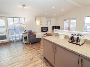 a kitchen and living room with a couch at Dovedale Lodge in Windermere