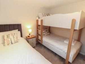 a bedroom with two bunk beds and a night stand at Dovedale Lodge in Windermere +29 photos