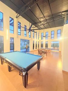 a pool table in a large room with windows at Moonstone Royal Resort in Jāmb