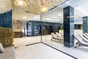 a lobby with glass walls and white chairs at Continental SPA in Bukovel +87 photos