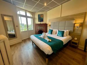 a bedroom with a large bed and a fireplace at Hotel de la Terrasse in Berck-sur-Mer +53 photos
