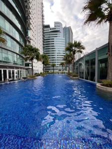 a large swimming pool in a city with tall buildings at Apartment klcc area in Kuala Lumpur