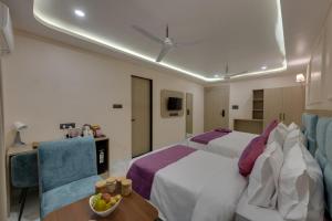 a hotel room with two beds and a table at Click Collection Ayodhya in Ayodhya +40 photos