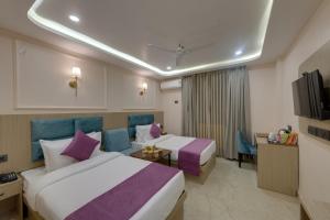 a hotel room with two beds and a television at Click Collection Ayodhya in Ayodhya