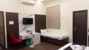 a bathroom with a bed and a sink and a mirror at Hotel Govindam Elite in Juhi Bari