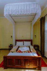 a bedroom with a bed with a canopy at Dream Kilimanjaro Complex Hotel in Msaranga