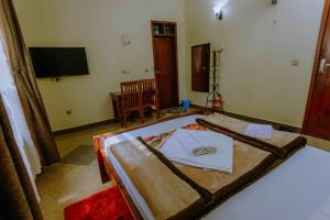 a room with a bed and a tv in it at Dream Kilimanjaro Complex Hotel in Msaranga