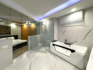 a bathroom with a tub and a shower and a sink at Amelia Terrace Escape in Tbilisi City +115 photos