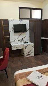 a room with a desk and a red chair at Hotel Govindam Elite in Juhi Bari +18 photos