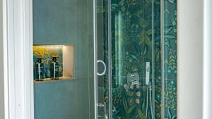 a glass shower door with bottles on a wall at TerrAmare Suites in Baronissi +145 photos