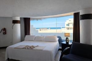 a bedroom with a bed and a view of the beach at Hotel Villa Capricho in Ciudad Madero