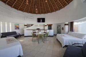 a hotel room with two beds and a table and chairs at Hotel Villa Capricho in Ciudad Madero