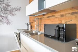 a kitchen with a microwave and a sink at APPARTAMENTO BELAGO by Design Studio in Bellano