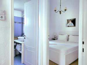 a white bedroom with a bed and a sink at House in Castle in Parikia