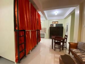 a living room with red curtains and a table at B2 Capsule Sleep Pods in Guiuan