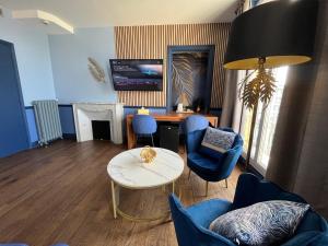 a living room with blue chairs and a table at Hôtel Windsor in Cannes