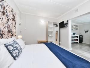 a bedroom with a large bed with a blue blanket at 32 Main Road in Struisbaai