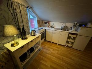 a small kitchen with a table with a lamp on it at Apartment Bjarmaland in Vestmannaeyjar