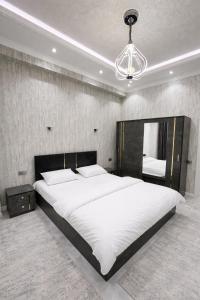 a bedroom with a large bed and a chandelier at Boulevard 2BR Luxury Apartment in Tashkent