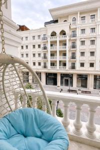 a chair on a balcony with a large building at Boulevard 2BR Luxury Apartment in Tashkent
