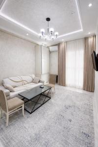 a living room with a bed and a table at Boulevard 2BR Luxury Apartment in Tashkent