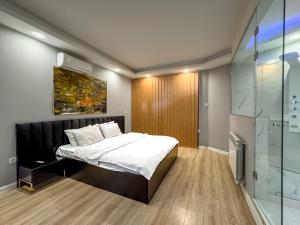 a bedroom with a bed and a glass shower at Amelia Terrace Escape in Tbilisi City