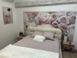 a bedroom with a bed with a painting of roses at chez Jess chambre d'hôte a UZES in Uzès