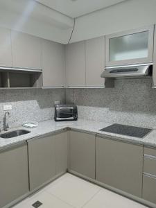 a kitchen with a sink and a microwave at Sweet Escape 22 at O Residences in Bacolod