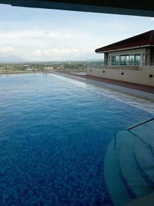 a large pool of blue water in front of a building at Sweet Escape 22 at O Residences in Bacolod