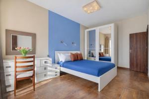 a bedroom with a blue bed and a chair at Stunning 3BR breathtaking views outdoor dining in Rabat