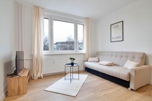 a white living room with a couch and a television at Moskovska with Public Parking in Banská Bystrica