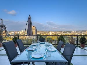 a table with wine glasses on a balcony with a view at Amelia Terrace Escape in Tbilisi City