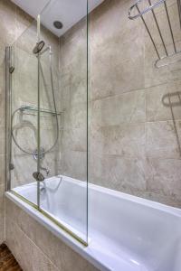 a bath tub with a glass shower in a bathroom at Stunning 3BR breathtaking views outdoor dining in Rabat +48 photos