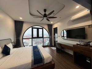 a bedroom with a large bed with a ceiling fan at Lâm Luxury Hotel Lào Cai in Chơ Mơi