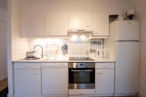 a kitchen with white cabinets and a white refrigerator at Fully equipped holiday home for 6 in Nieuwpoort
