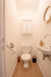 a white bathroom with a toilet and a sink at Fully equipped holiday home for 6 in Nieuwpoort +16 photos