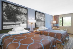 a hotel room with two beds in a room at Super 8 by Wyndham Brinkley in Brinkley +21 photos