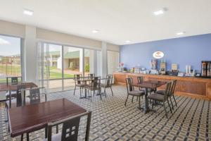 a restaurant with tables and chairs and a counter at Super 8 by Wyndham Brinkley in Brinkley