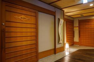 a hallway with two wooden doors and a lamp at Biwako Grand Hotel Kyo-Ohmi in Otsu +17 photos