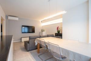 a dining room with a table and a couch at Amazing apartment for 8 with parking space in Ostend
