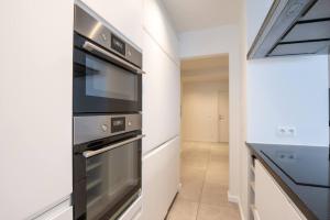 a kitchen with a stainless steel stove and a hallway at Amazing apartment for 8 with parking space in Ostend