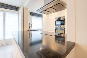 a kitchen with a glass counter top and a stove at Amazing apartment for 8 with parking space in Ostend